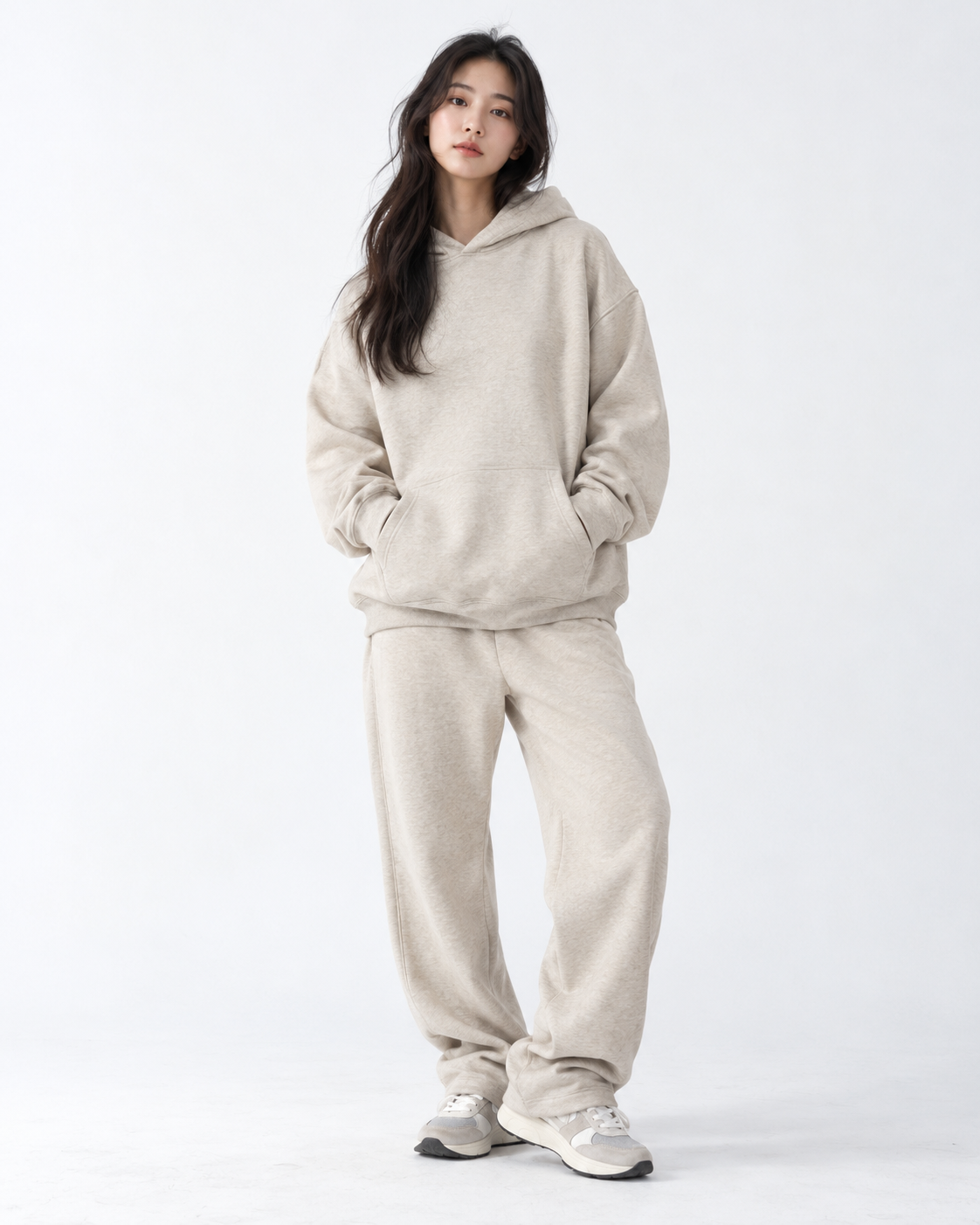 Model wearing a cream hoodie and tonal sweatpants